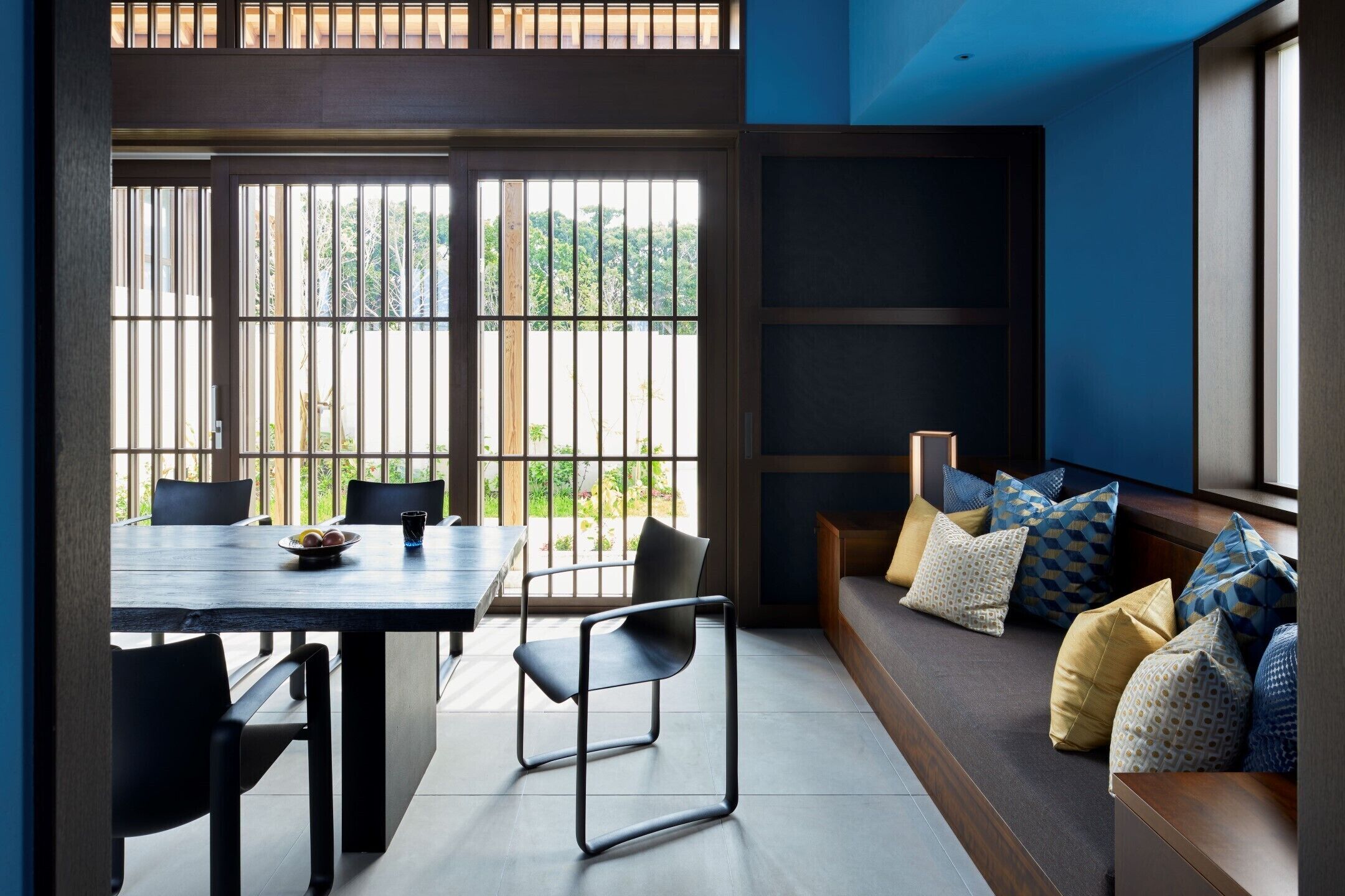 A modern interior with a dining area, seating, and large windows.