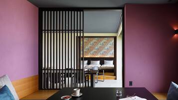 Una habitación con una mesa negra, un sofá y un separador decorativo.