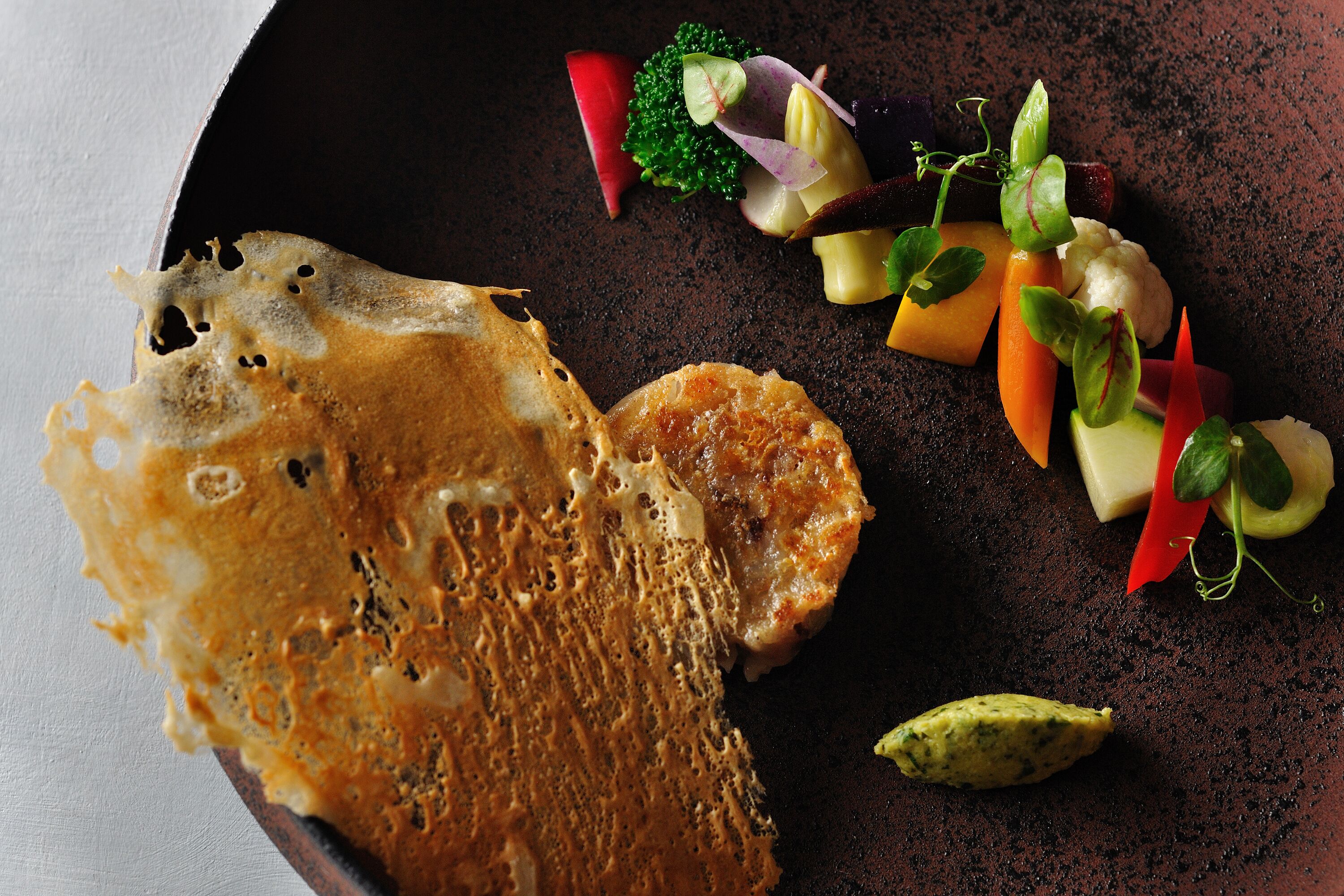 A plate with a piece of bread and a variety of vegetables.
