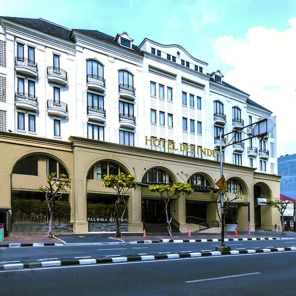 A multi-story hotel with a classic architectural style, featuring arched windows and balconies.