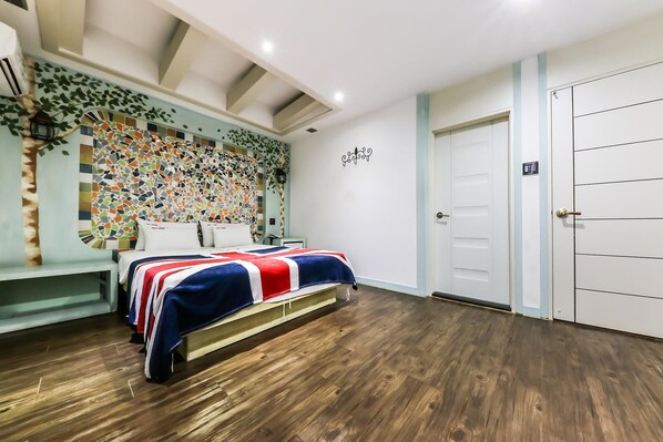 A bedroom with a bed, a wall with a mosaic pattern, a door, and a bench.