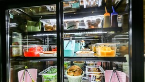 A refrigerated display case with various food items and condiments. - Born Hotel Cheongju (Cheongju)