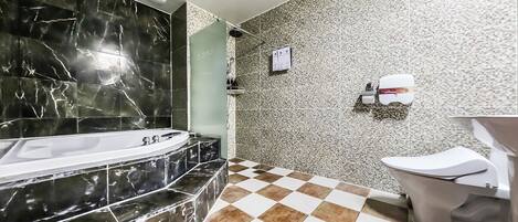 A bathroom with a black marble bathtub, a checkered floor, and a toilet with a paper towel dispenser.