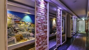 A hallway with a view of a coastal town through a large window, brick walls, and a marble floor. - Born Hotel Cheongju (Cheongju)