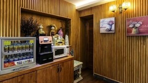 A wooden wall with vertical slats, a vending machine, a microwave, and decorative items. - Born Hotel Cheongju (Cheongju)