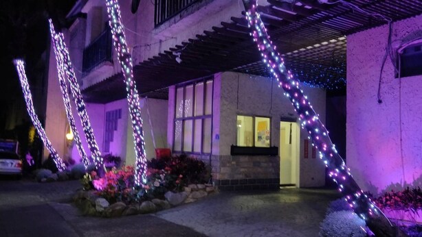 A building with a stone facade, a covered entrance, and decorative lights. - Wen Mei Motel (Nantou)