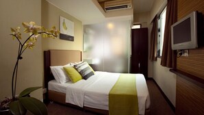 A hotel room with a bed, a TV, a potted plant, and a window. - Casa (Kowloon)