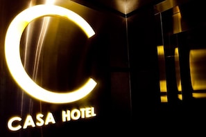 A sign for a hotel with a large illuminated 'C' and the words 'CASA HOTEL' below it. - Casa (Kowloon)