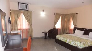 Ein Hotelzimmer mit Bett, Schreibtisch, Stuhl und einem kleinen Tisch.