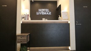 A hotel reception desk with a sign reading "HOTEL LIVEMAX". There are two doors labeled "Staff Only" on either side of the desk. - Hotel Live Max Tokyo Kanda Station (Tokyo)