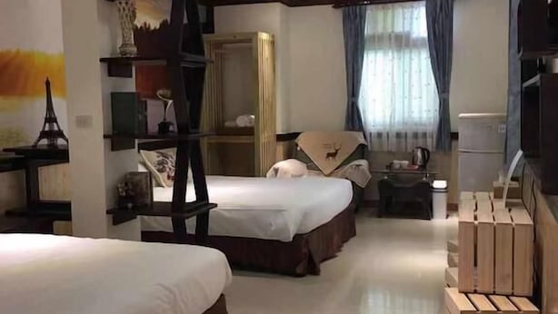 A hotel room with two beds, a wooden ladder, a minibar, and a large window with curtains. - Cheng Lan Hotel (Yuchi)
