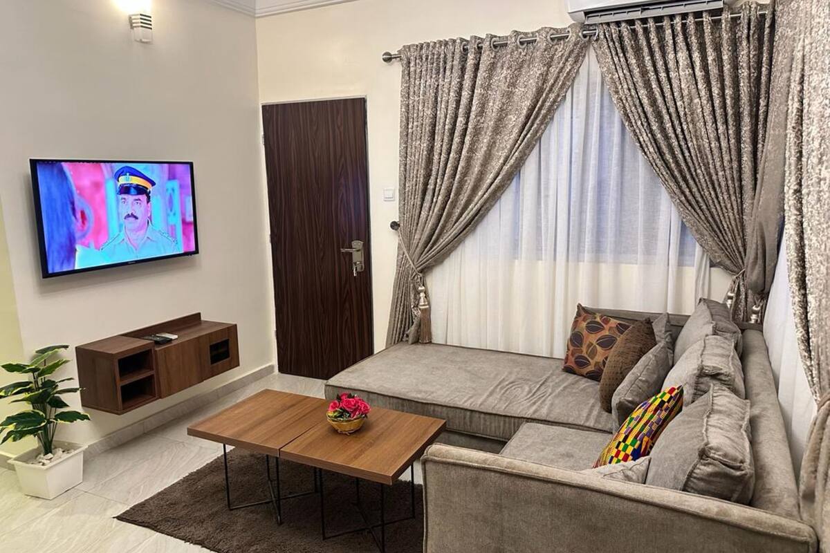 A living room with a sofa, a coffee table, a TV, and a door.