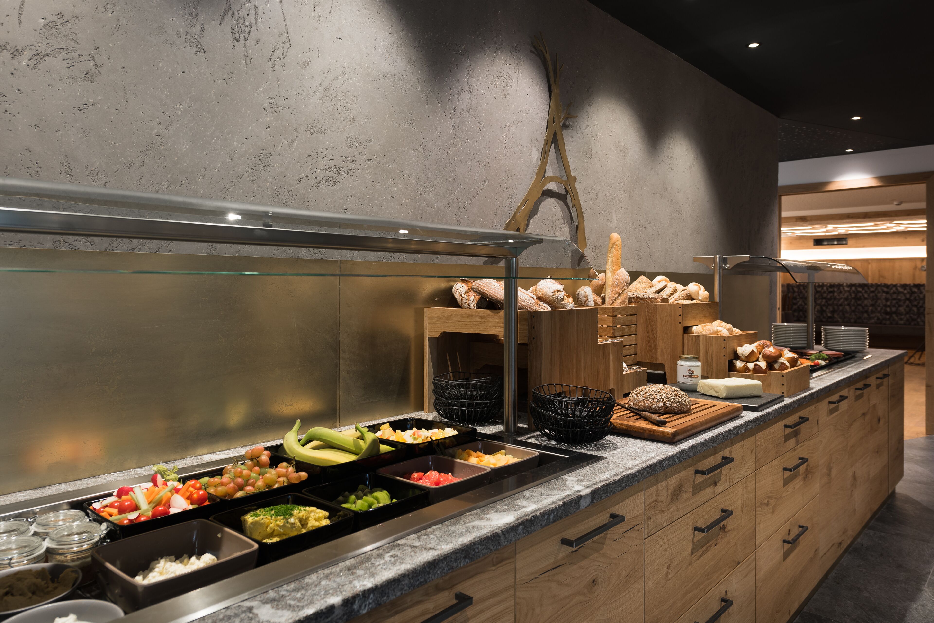 Un buffet proposant une variété d’aliments, notamment des fruits, des légumes et du pain.