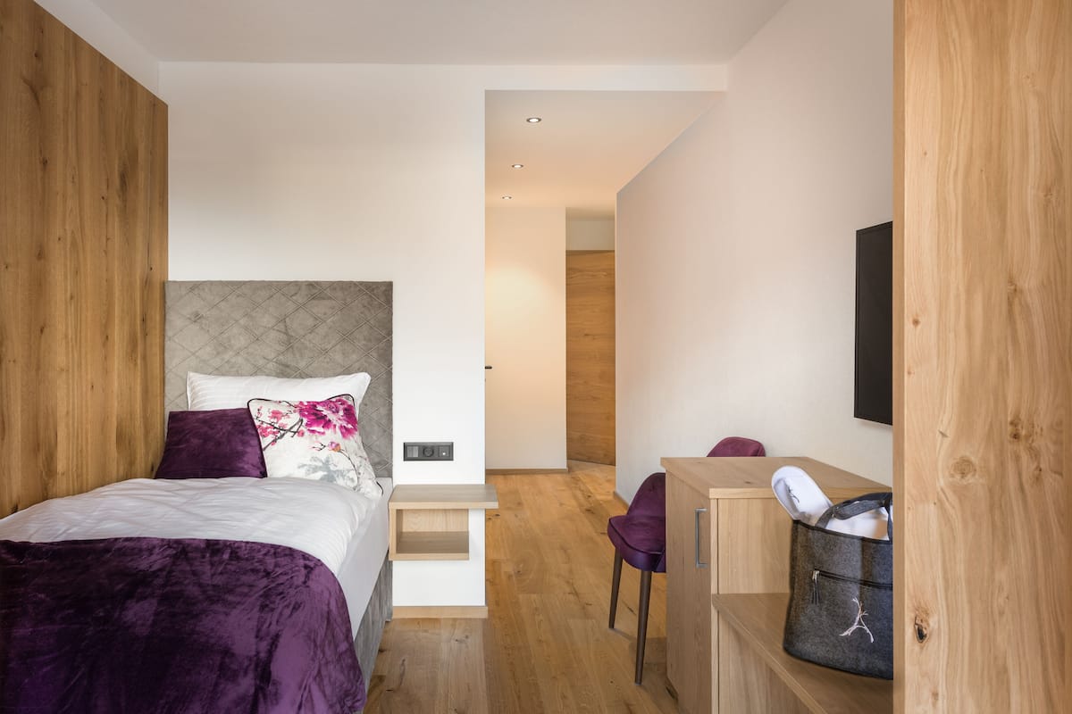 A modern bedroom with a bed, a desk, and a chair.