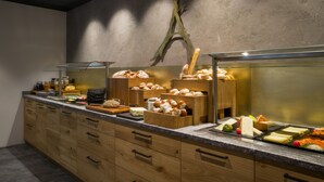 Buffet com diversos alimentos e armários de madeira.