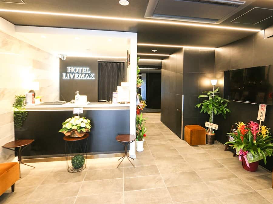 Zona de recepción de un hotel, con mostrador de recepción, un cartel que dice