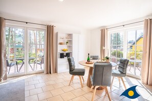 Une chambre moderne dotée d’un coin repas, de grandes fenêtres et offrant une vue sur l’extérieur.