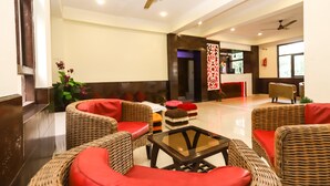 A spacious lobby with wicker furniture and a glass coffee table. - Hotel The Nest (Dharamshala)