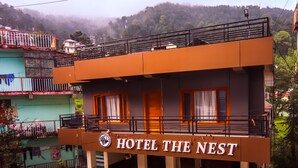 A two-story building with a balcony and a sign reading "HOTEL THE NEST". - Hotel The Nest (Dharamshala)