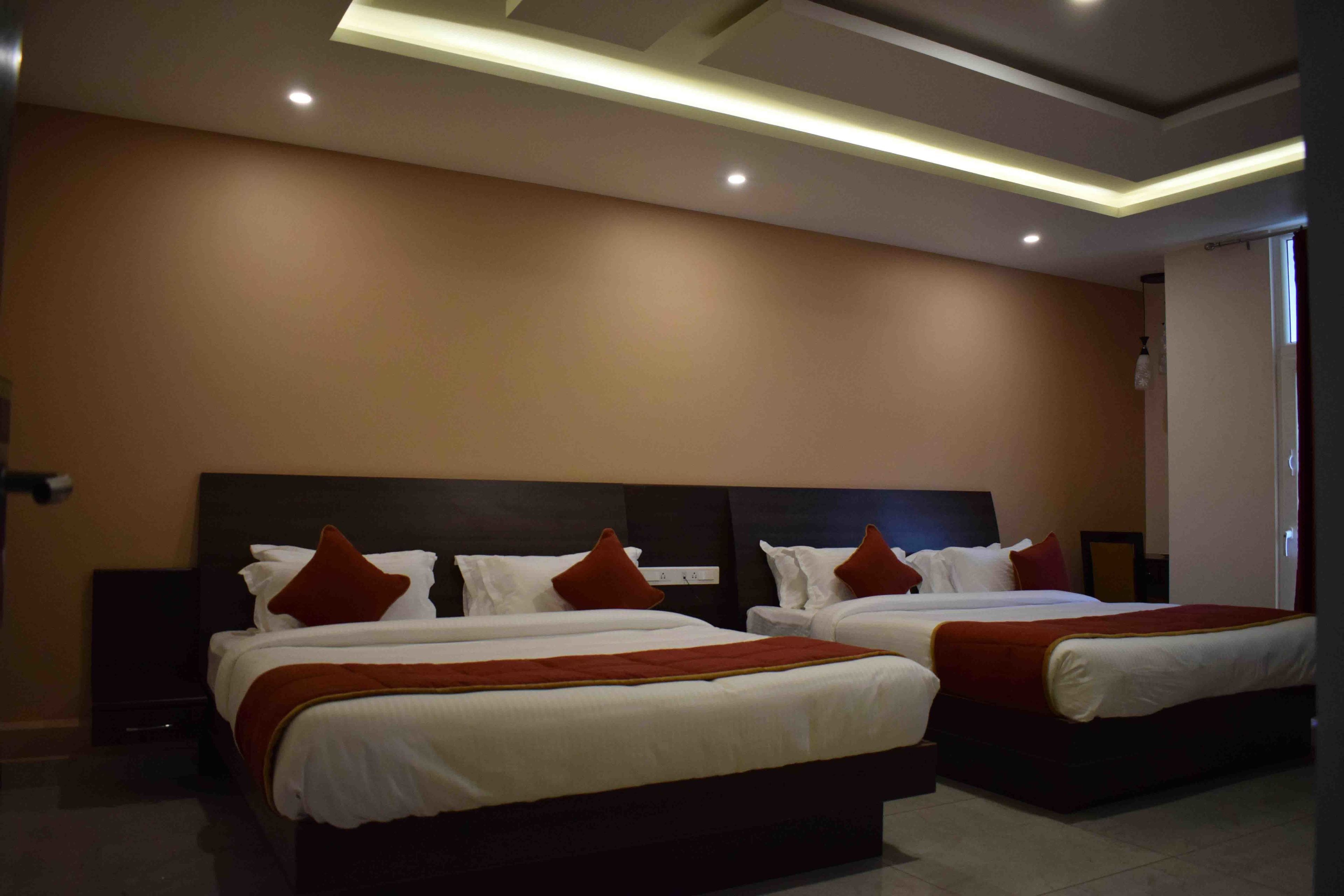 A hotel room with two beds, a dark headboard, and a modern ceiling design.