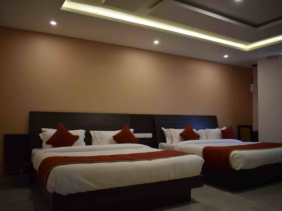 A hotel room with two beds, a dark headboard, and a modern ceiling design.
