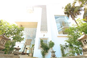 Un edificio moderno con fachada de vidrio, faroles de piedra y una escalera central.