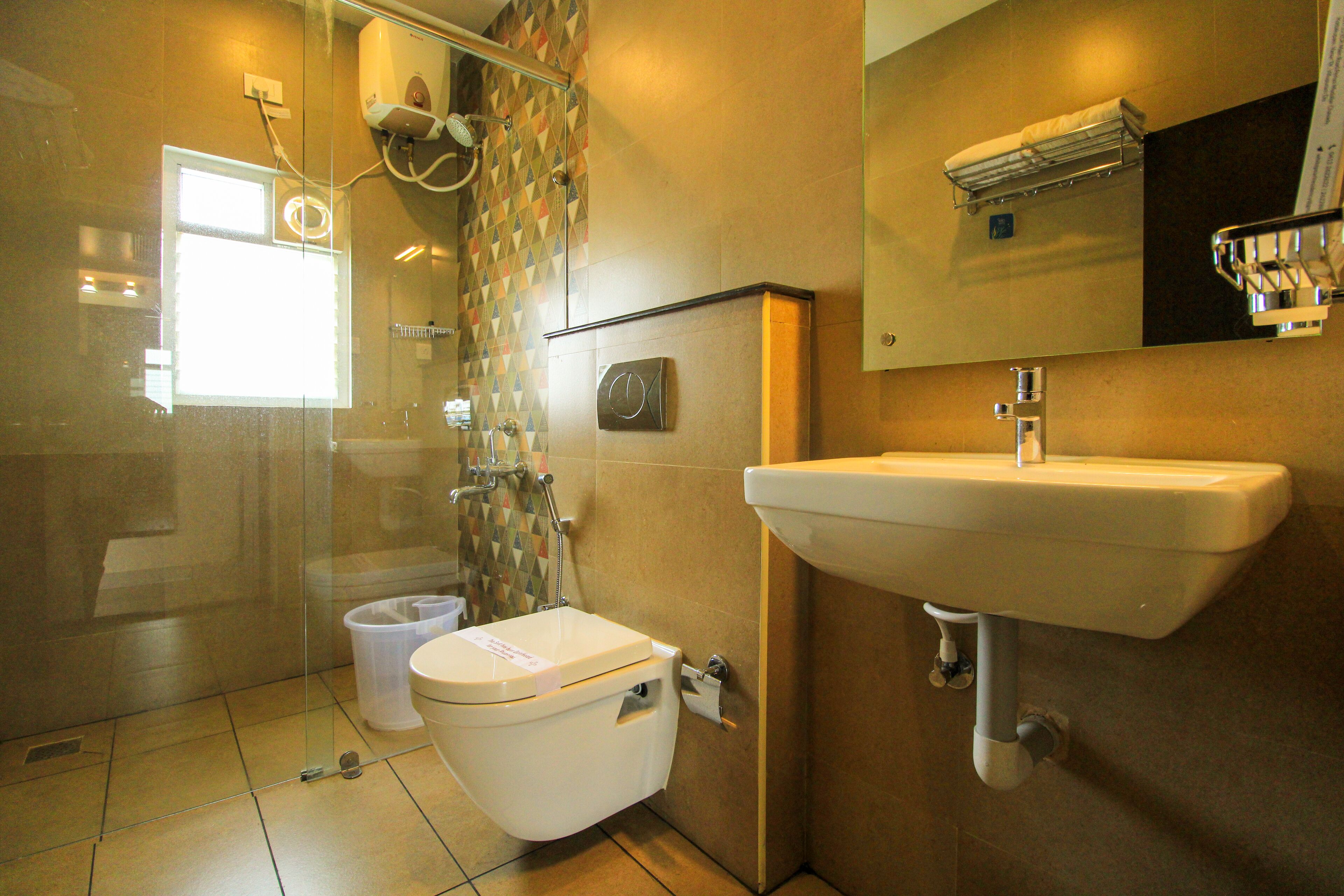 Een moderne badkamer met een douchecabine van glas, een toilet en een wastafel.