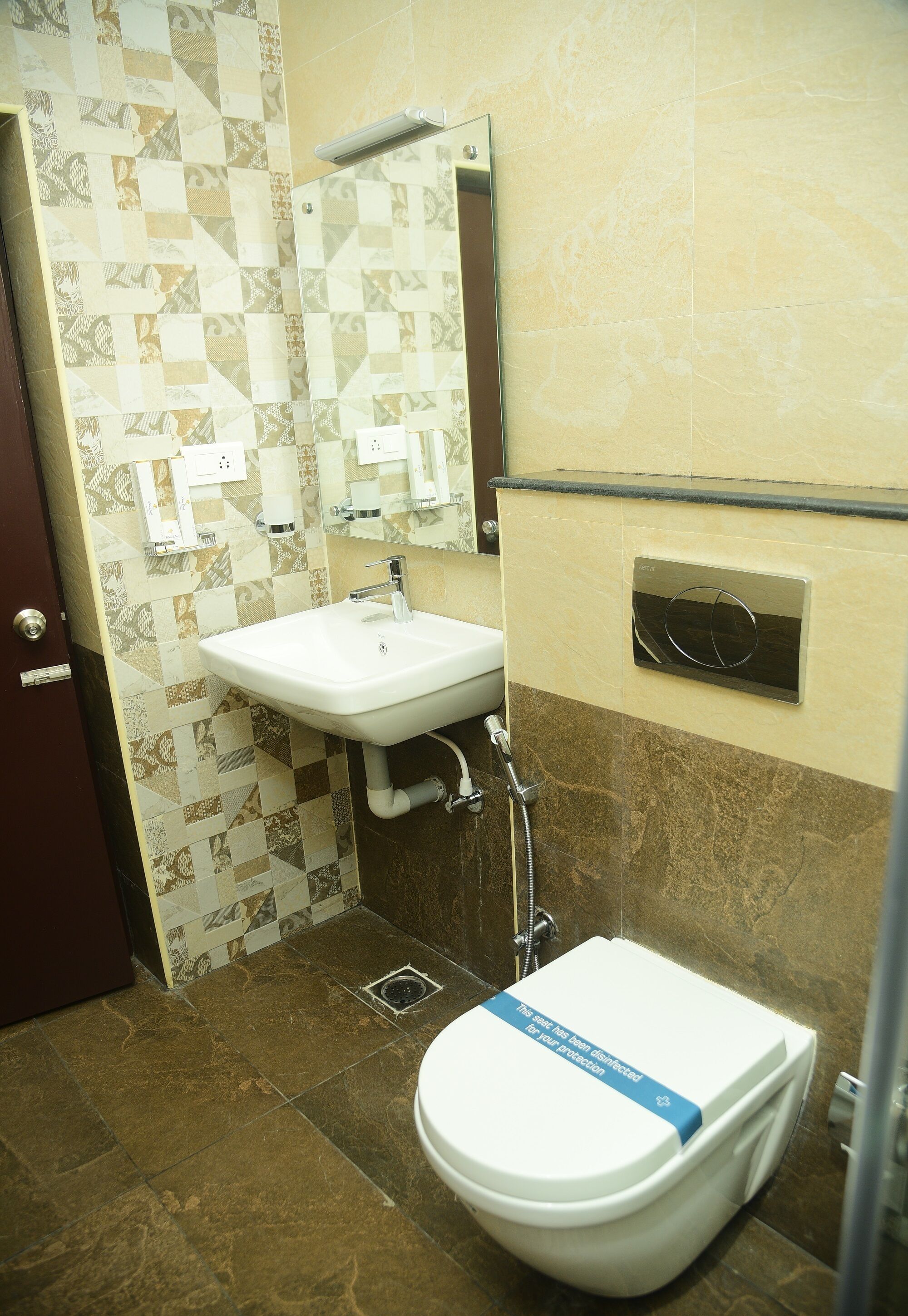 Een badkamer met een wit wastafel, een spiegel, een douche en een toilet.