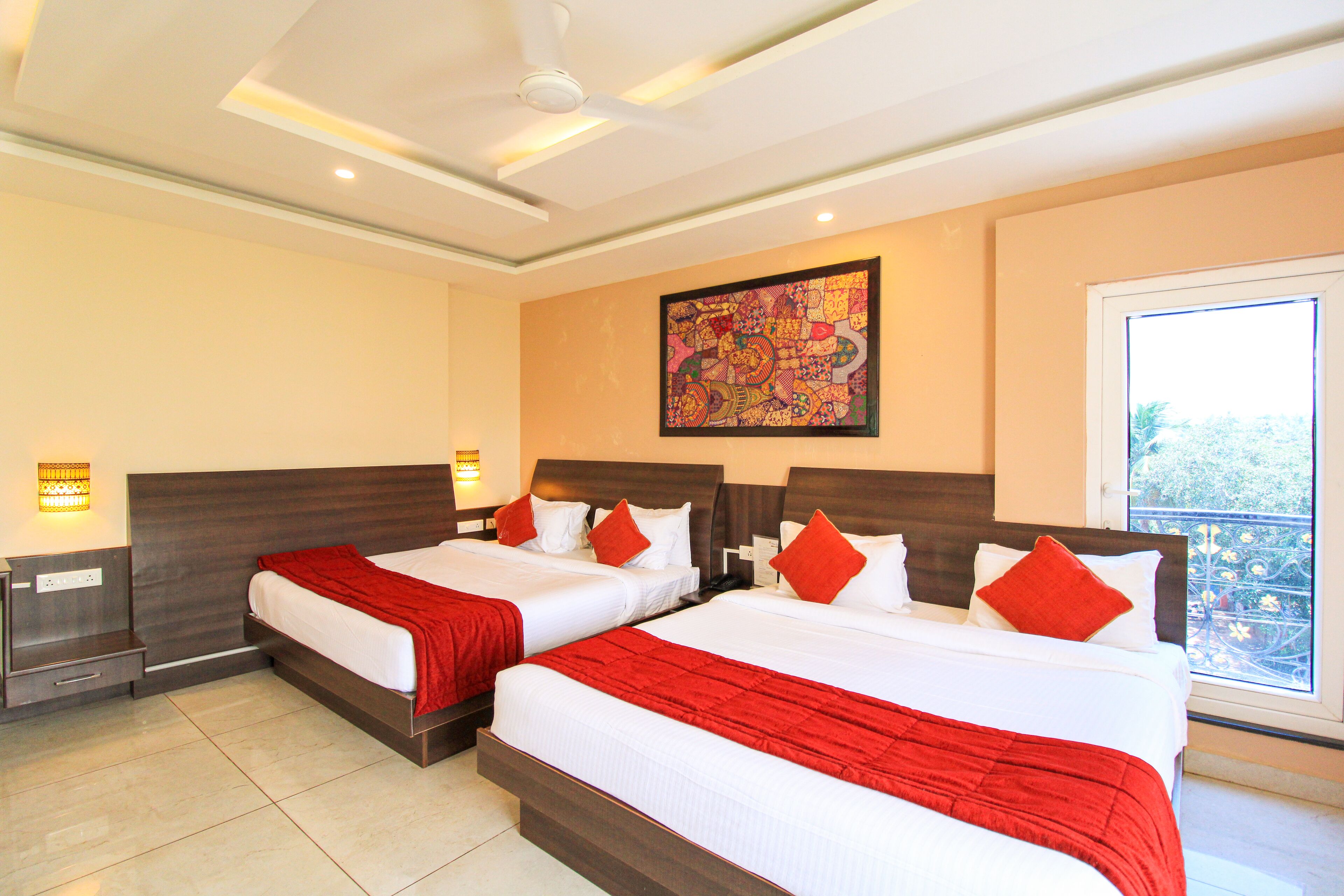 A hotel room with two beds, a large window, and a ceiling fan.