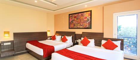 A hotel room with two beds, a large window, and a ceiling fan.