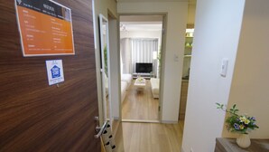 Ein Hotelzimmer mit Holzboden, einem Fernseher im Wohnbereich und einem Schild, das freies WLAN anzeigt.
