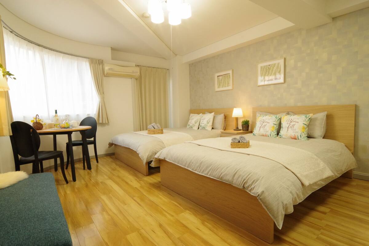 A hotel room with two beds, a desk, and a chair.