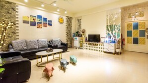 A modern living room with a black sofa, a coffee table, and decorative animal sculptures. - Zheng Yi Homestay (Taitung)