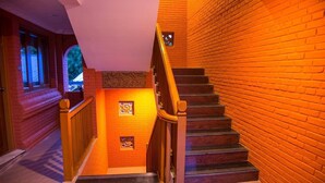 A staircase with wooden handrails and brick walls, leading to an upper floor. - WEStay at Boutique House Bagan (Nyaung-U)