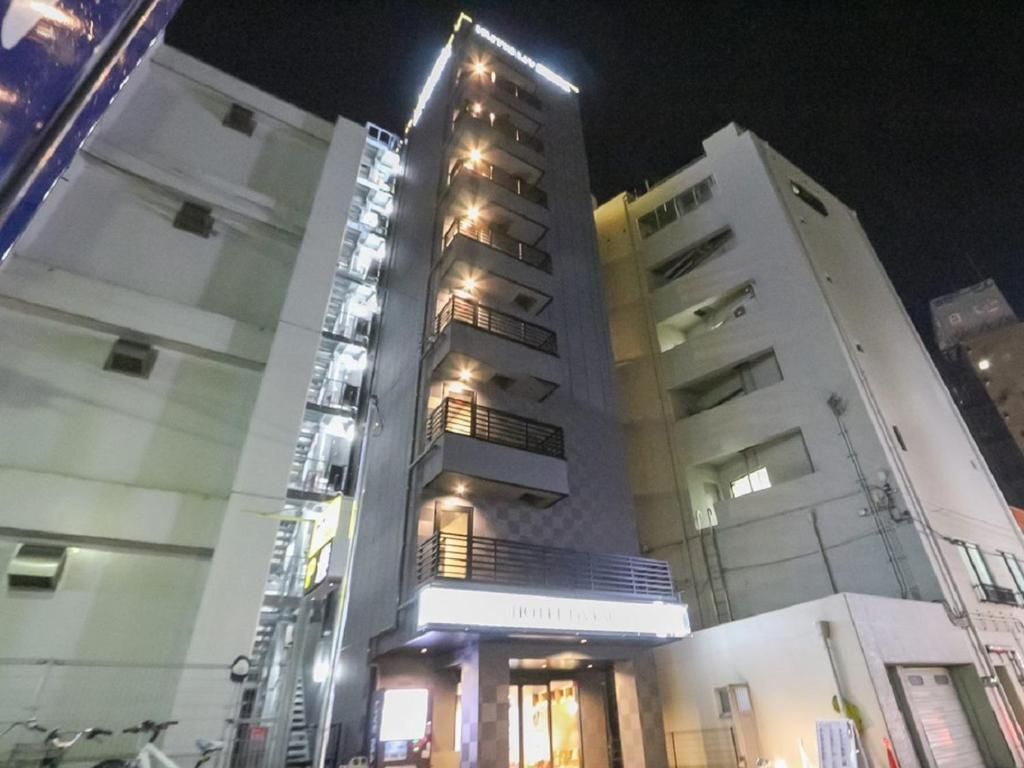 A multi-story hotel with a prominent entrance and a staircase leading to the upper floors.