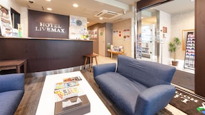 A hotel reception area with a reception desk, seating area, and a view of the lobby. - Hotel Livemax BUDGET Shimbashi (Tokyo)