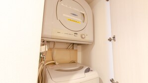 A white clothes dryer with a control panel and a label in a foreign language. - Hotel Livemax BUDGET Shimbashi (Tokyo)