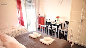 A bedroom with a bed, a small table with a chair, and a window with curtains. - Residenza Alla Piazzetta (Verona)