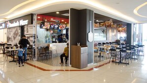 Ein Food-Court mit einem Domino's Pizza Restaurant, Sitzgelegenheiten und einer Theke.