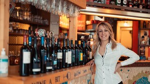 Zona de bar con selección de vinos y pared de mosaicos.