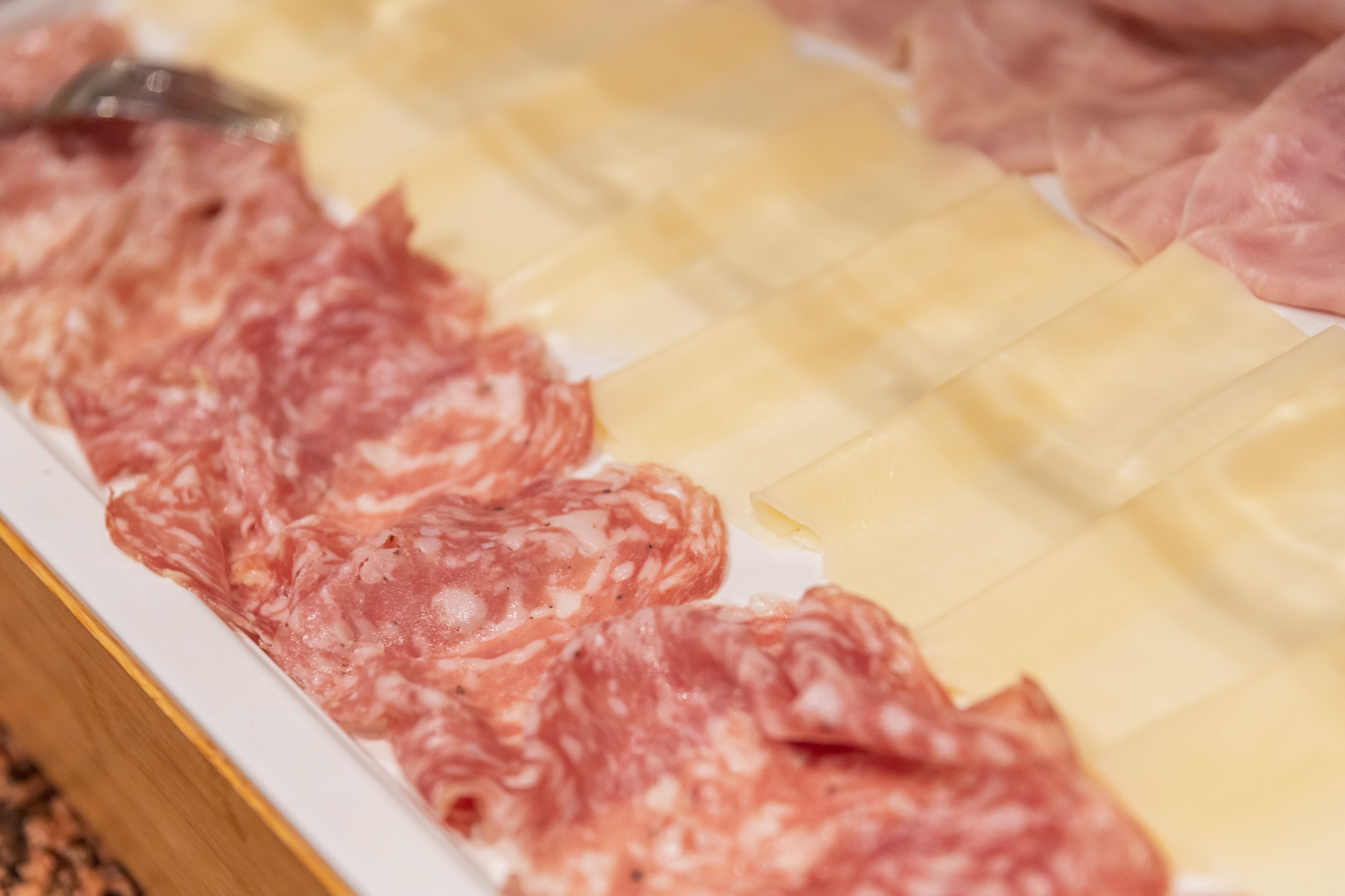 Un assortimento di salumi e formaggi su un vassoio.