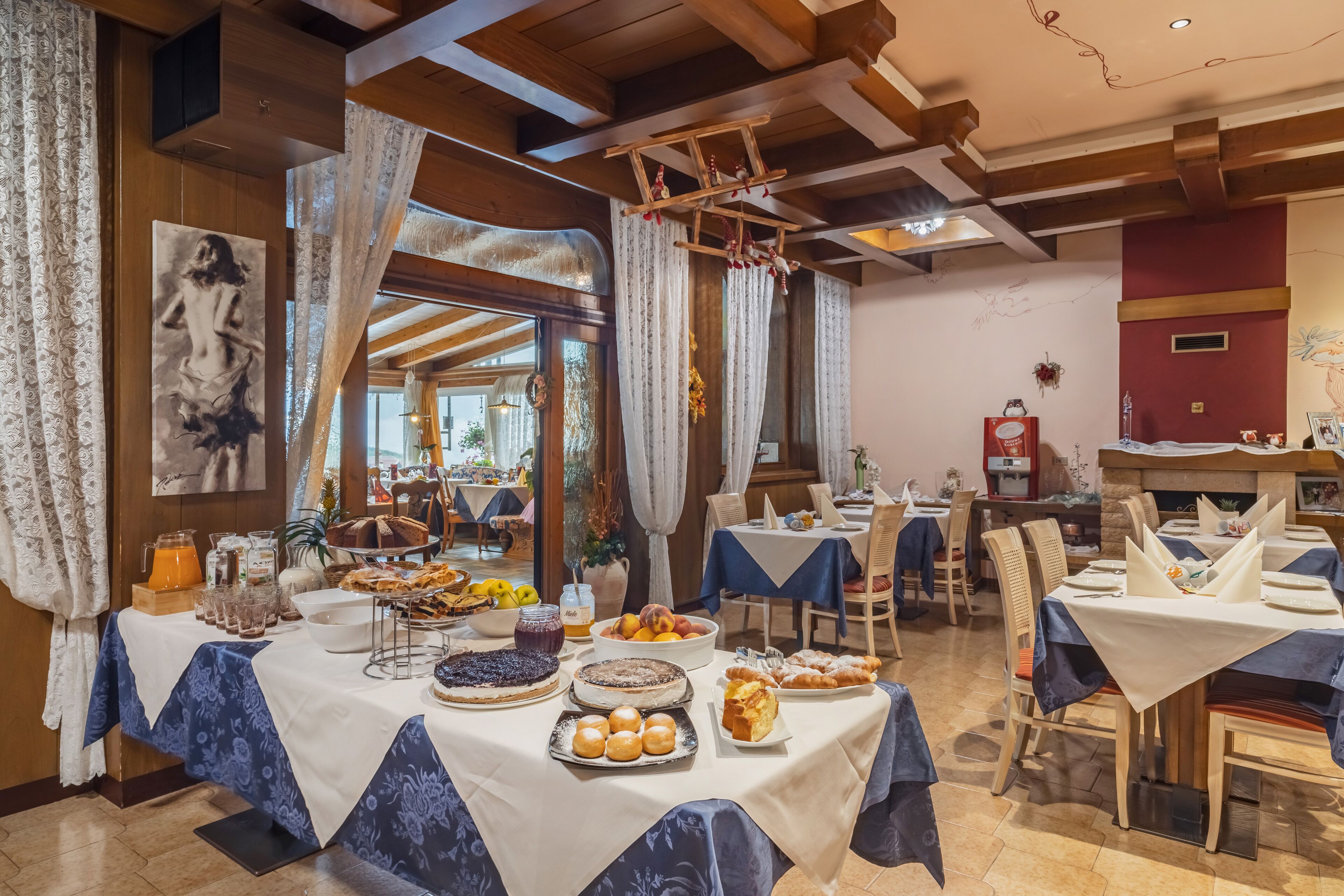 A dining area with tables set for a meal, featuring a variety of dishes and a buffet.