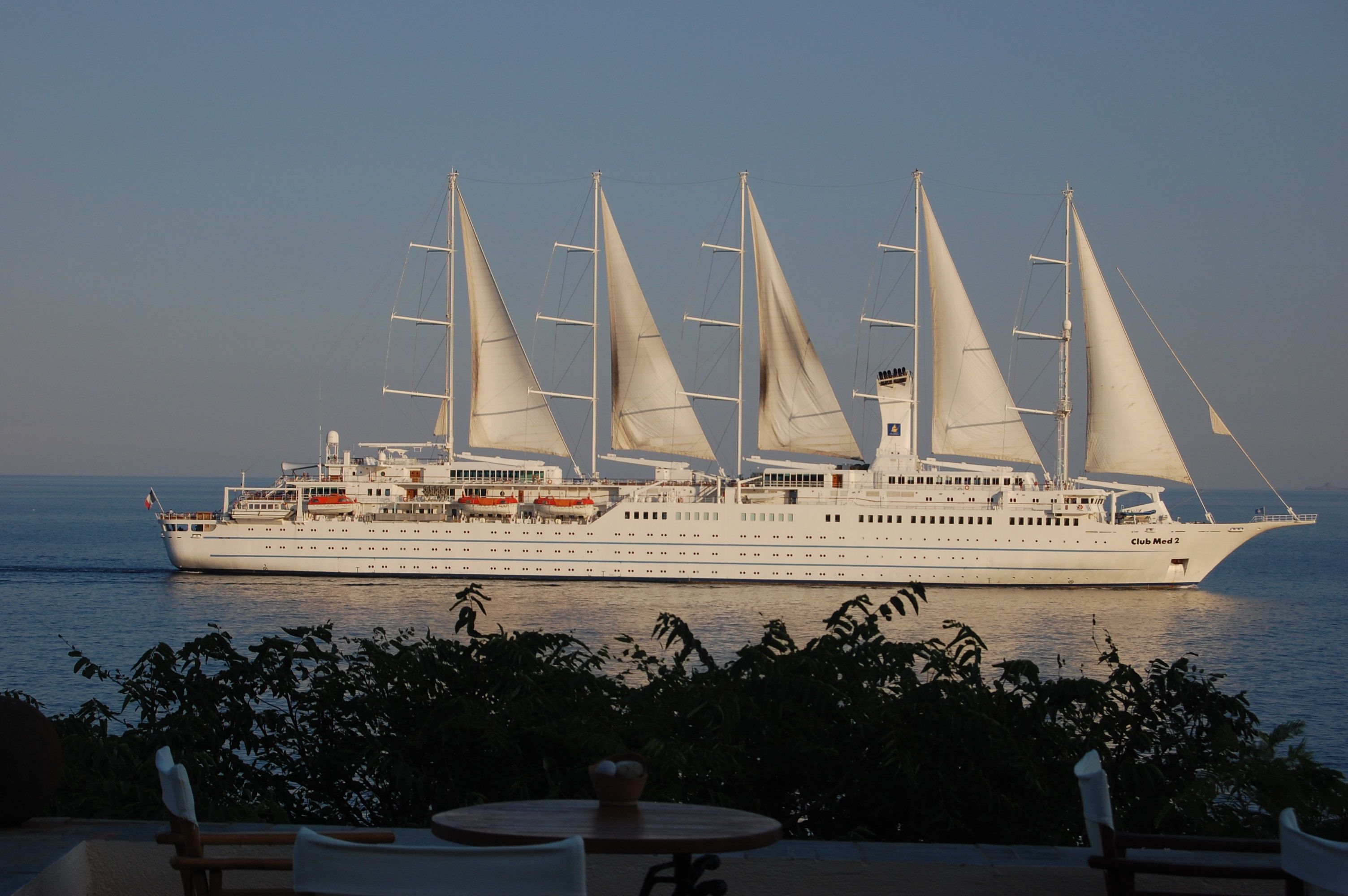 Un gran crucero con numerosas velas amarrado en un puerto.