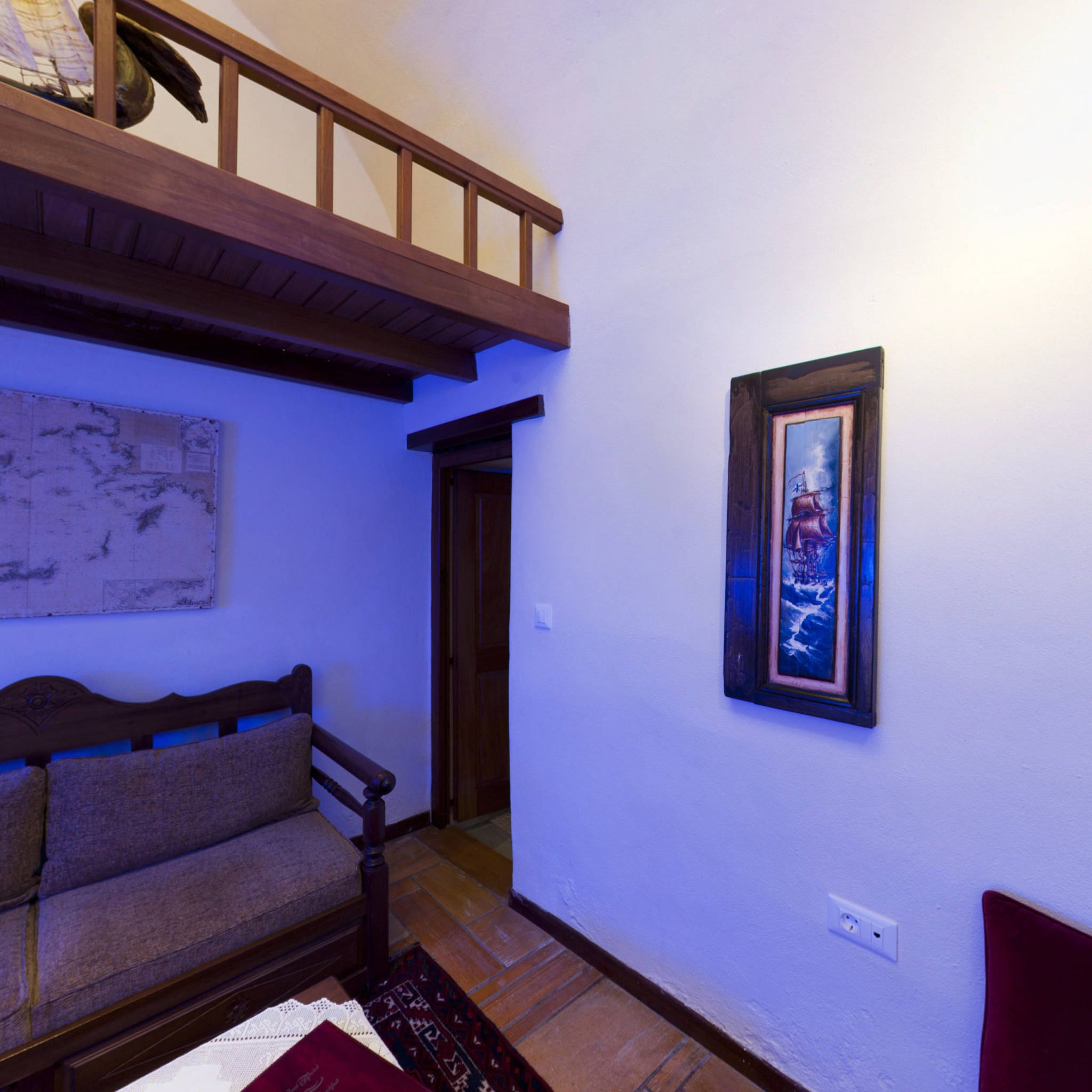 A room with a wooden bench, a framed picture on the wall, and a map on the wall.