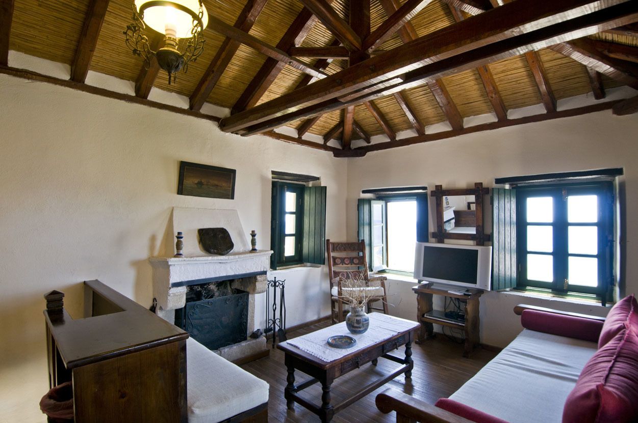A traditional room with a fireplace, wooden furniture, and a television.