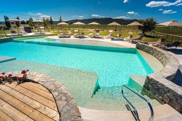 Een seizoensgebonden buitenzwembad en parasols bij het zwembad