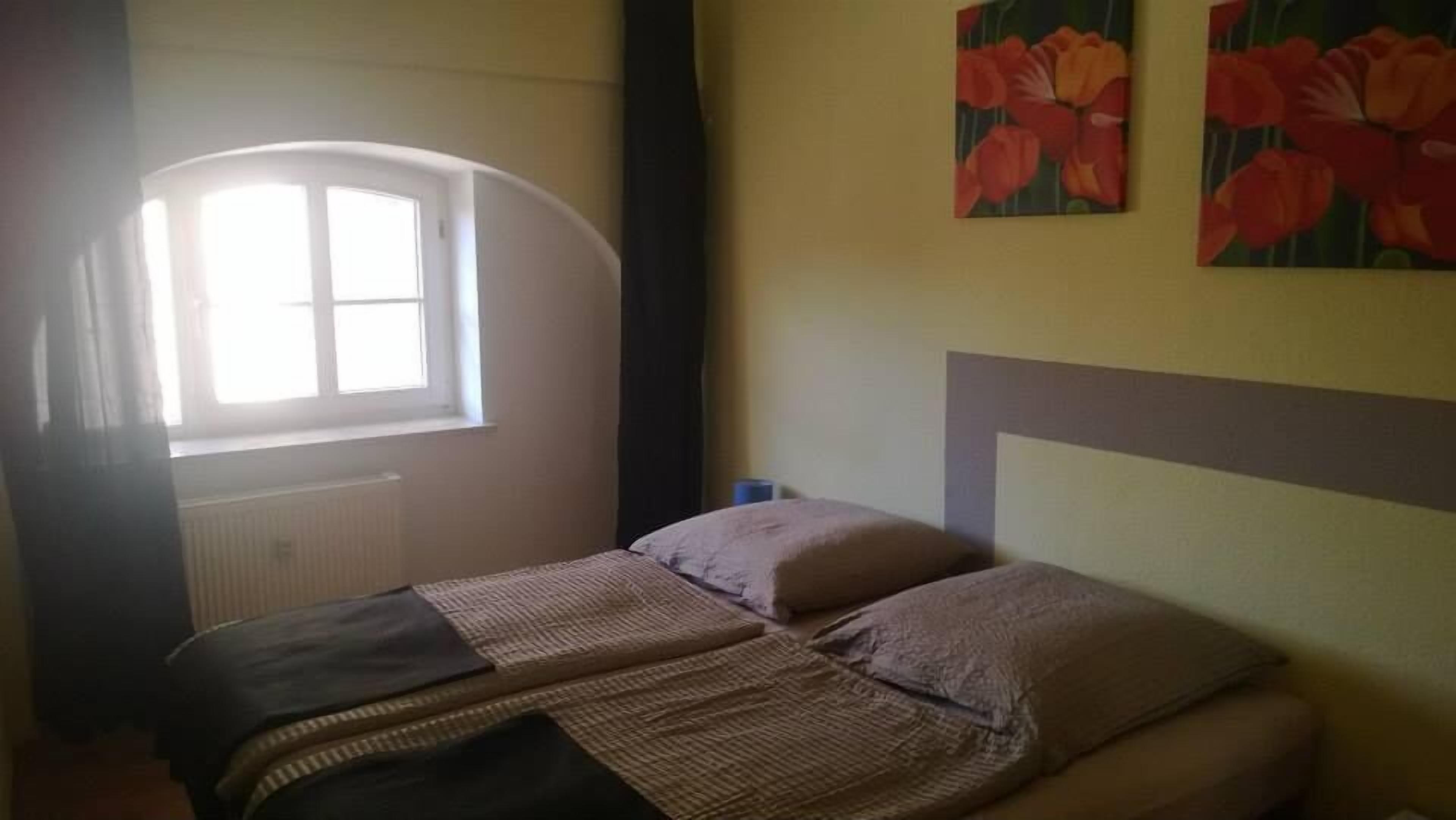 Ein Schlafzimmer mit einem Bett, einem Fenster und einem Bild an der Wand.