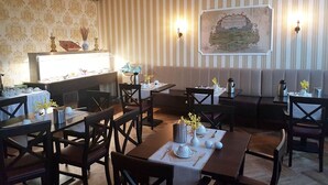 A restaurant with striped wallpaper, a map on the wall, and tables set with white tableware. - Ferienwohnungen Peitz (Peitz)