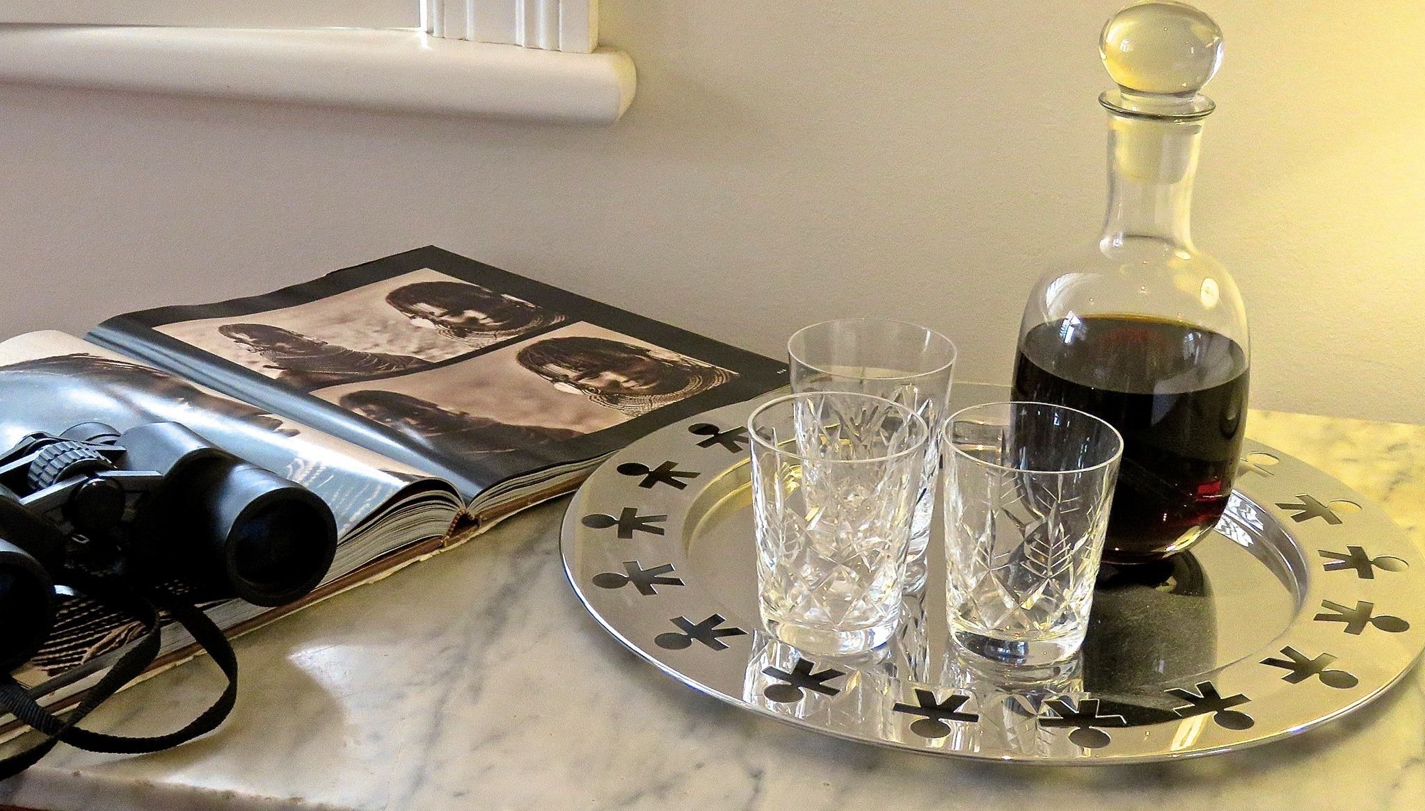 A table with a book, a bottle of wine, and two glasses.