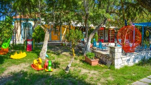 A children's play area with swings, slides, and a climbing structure. - Xi Village (Kefalonia)